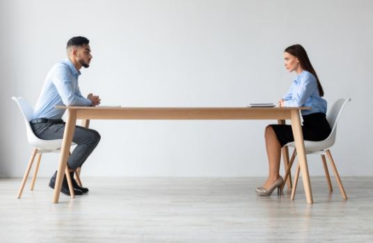 Businessman and Businesswoman sitting opposite sides table