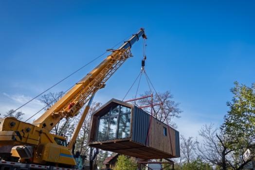 Modular Construction’s Big Boom: New Risks Outpacing Standard Contracts in Industrial Projects House being transported by crane