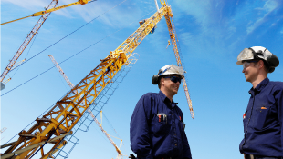 Federal Court Opinion Has Huge Impact on the Construction Industry Two construction workers talking in front of crane