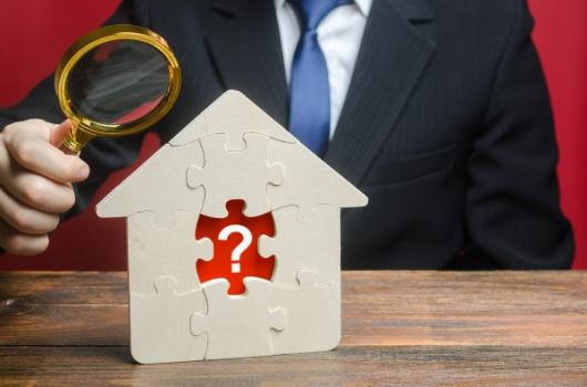House puzzle question mark in center man with magnifying glass