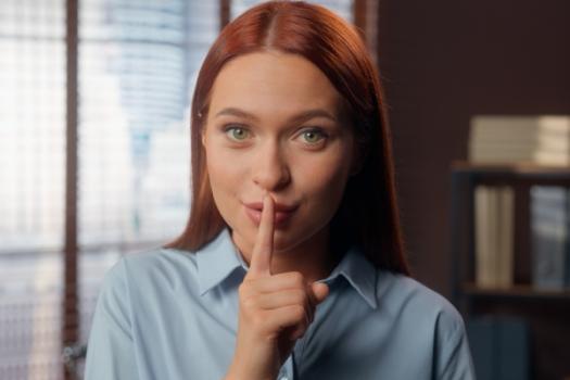 Woman finger mouth in shh secret gesture