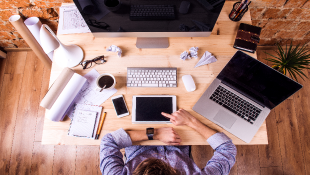 The Four Forces That Will Take on Concrete and Make Construction Smart businessman at desk covered with smart technology objects