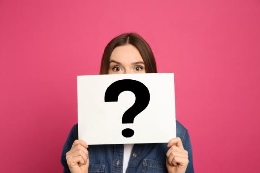 Woman holding up question mark sign