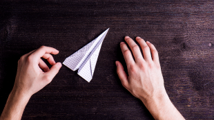 Denver Airport Terminates P3 Contract For Main Terminal Renovation Desk hands holding paper airplane