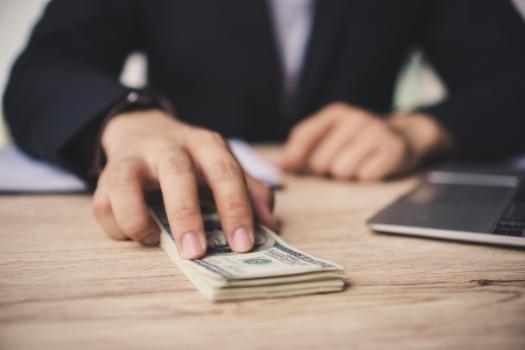 Person pushing money across desk