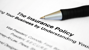 A Primer on Insurance for Construction Projects Pen resting on insurance policy
