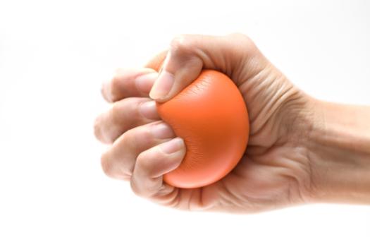 Hand clenching orange