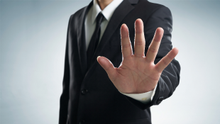 Businessman with hands up in stop gesture