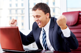 Businessman in triumph in front of laptop