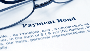 Glasses lying on Payment Bond document