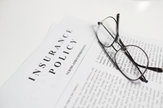 The Non-Imputation Affidavit in Real Estate Title Insurance Glasses lying on insurance policy