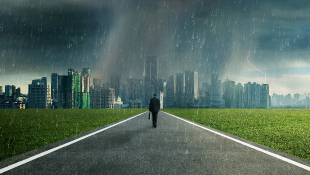 Businessman walking through storm toward city