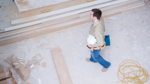“License and Registration, Please.” The Big Risk of Getting Busted for Working without a Proper Contractor’s License Architect carrying plans through corridor