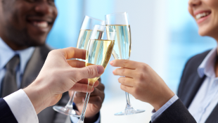 Celebrating Dave McLain’s Recognition in the Best Lawyers in America® 2025 Business partners clinking champagne glasses