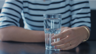 Woman's hand holding glass of water