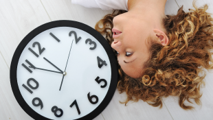 Woman lying next to clock