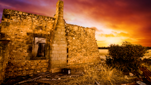 Sun sets over old ruined building