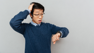 Man looking at watch with late expression