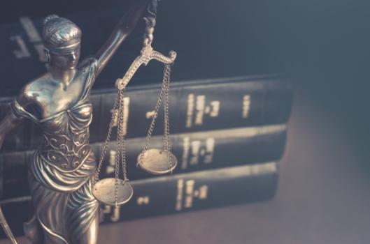 Scales of justice law books behind it