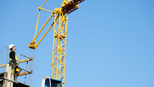 Construction worker operating crane