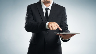 SkenarioLabs Uses AI for Property Benchmarking Businessman pointing to tablet