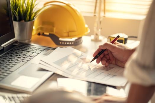 Desk with construction hard hat and budget docs